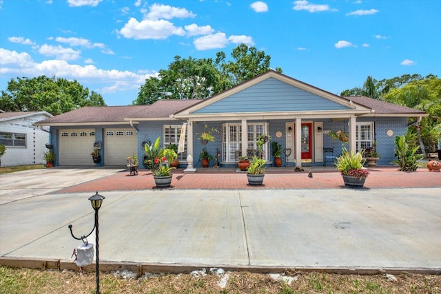 view of front facade featuring covered porch, driveway, brick siding, and a garage