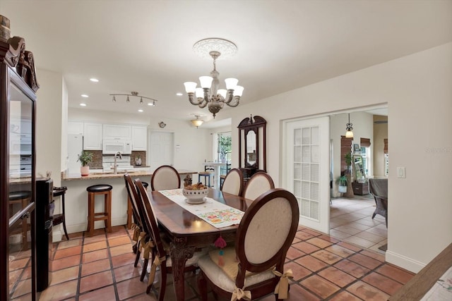 dining space featuring baseboards, a chandelier, recessed lighting, and light tile patterned flooring