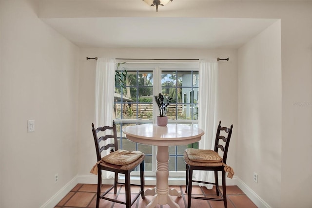 tiled dining area featuring baseboards