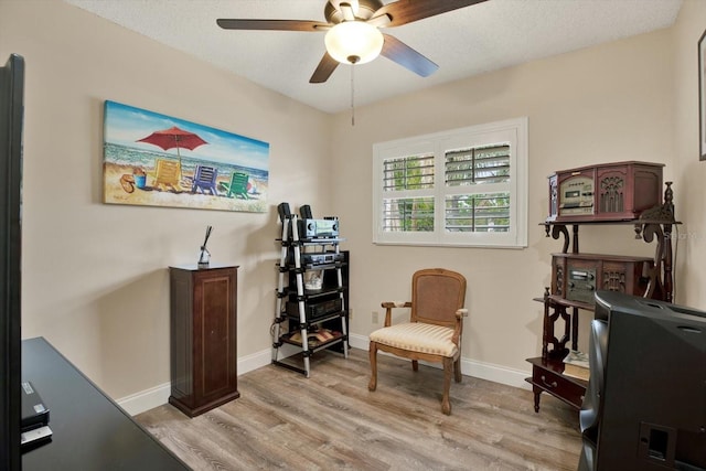 interior space featuring baseboards, light wood-style floors, and ceiling fan