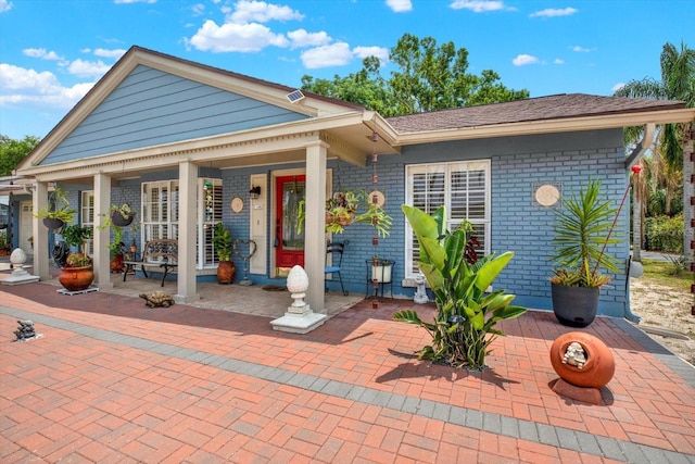 view of front of home featuring a patio area and brick siding