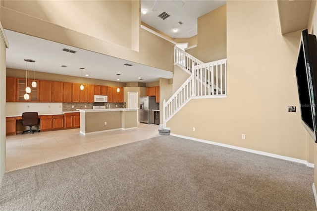 4335 Canongate Ct, Spring Hill, FL 34609 - unfurnished living room with light carpet, light tile patterned flooring, baseboards, stairs, and a high ceiling