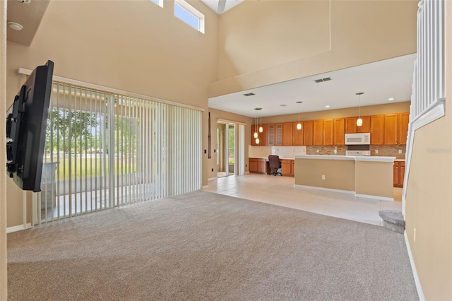4335 Canongate Ct, Spring Hill, FL 34609 - unfurnished living room featuring light colored carpet, healthy amount of natural light, light tile patterned floors, and a towering ceiling