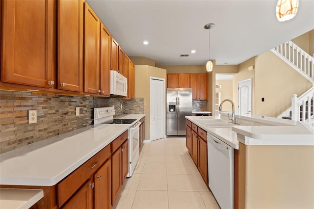 4335 Canongate Ct, Spring Hill, FL 34609 - kitchen featuring white appliances, a sink, brown cabinets, backsplash, and light tile patterned floors