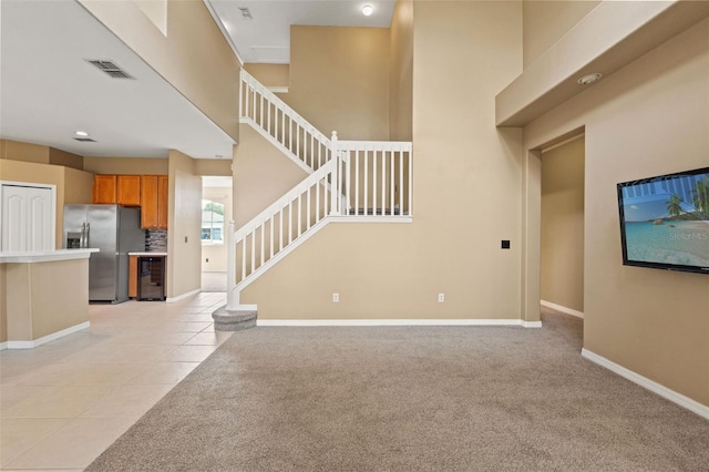 4335 Canongate Ct, Spring Hill, FL 34609 - unfurnished living room featuring wine cooler, stairway, baseboards, light colored carpet, and light tile patterned floors