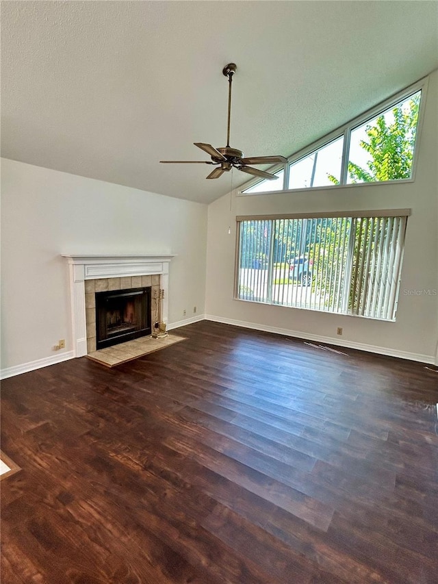 7444 Candlelight Ct, New Port Richey, FL 34652 - unfurnished living room featuring a ceiling fan, a tiled fireplace, wood finished floors, and high vaulted ceiling