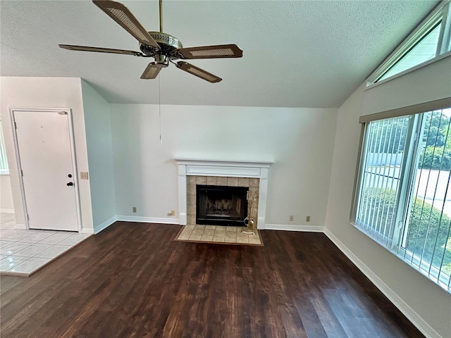 7444 Candlelight Ct, New Port Richey, FL 34652 - unfurnished living room with wood finished floors, a textured ceiling, healthy amount of natural light, ceiling fan, and a tile fireplace