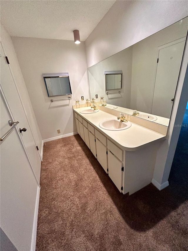 7444 Candlelight Ct, New Port Richey, FL 34652 - bathroom with double vanity, a textured ceiling, and carpet flooring