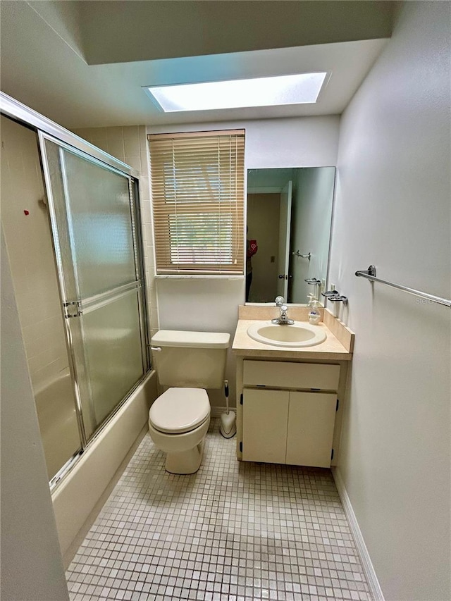7444 Candlelight Ct, New Port Richey, FL 34652 - bathroom featuring a skylight, vanity, bath / shower combo with glass door, and tile patterned flooring