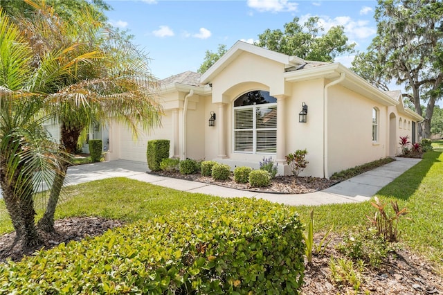 4407 Caliquen Dr, Brooksville, FL 34604 - ranch-style home with a front yard, an attached garage, concrete driveway, and stucco siding