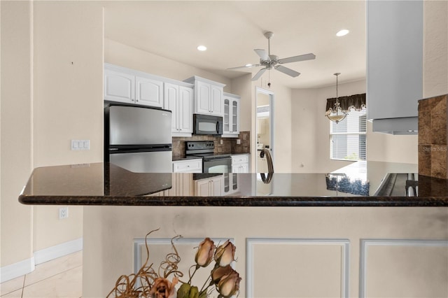 4407 Caliquen Dr, Brooksville, FL 34604 - kitchen with ceiling fan with notable chandelier, a peninsula, white cabinetry, black appliances, and decorative backsplash