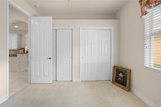 4407 Caliquen Dr, Brooksville, FL 34604 - bedroom with arched walkways, multiple windows, light colored carpet, and multiple closets