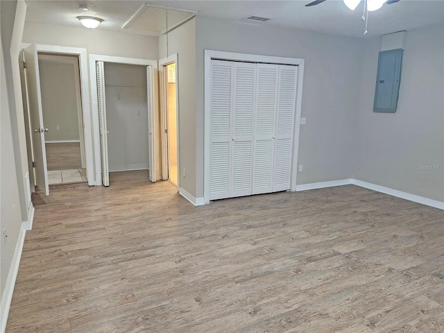 18232 Monteverde Dr, Spring Hill, FL 34610 - unfurnished bedroom with baseboards, electric panel, attic access, two closets, and wood finished floors