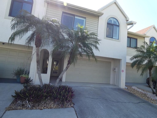 view of front facade featuring a garage, stucco siding, and concrete driveway