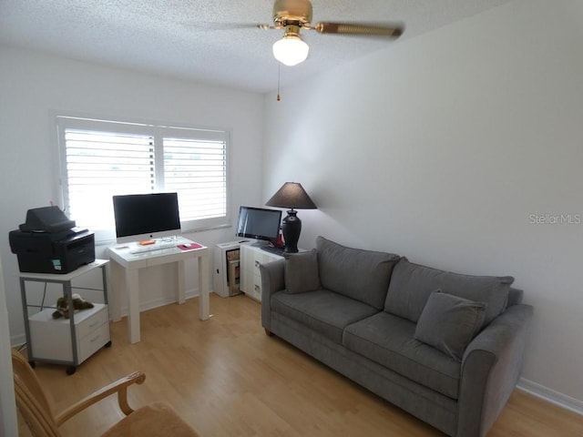 interior space with a ceiling fan, a textured ceiling, and light wood-style floors