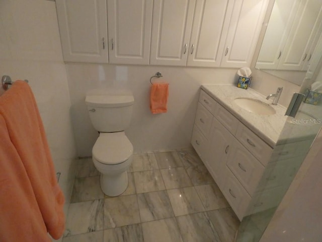 bathroom with vanity, toilet, and marble finish floor