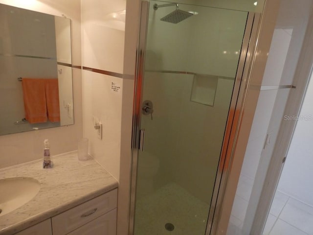 full bath with vanity, tile patterned flooring, and a stall shower