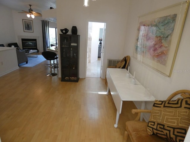 hall featuring light wood finished floors and visible vents