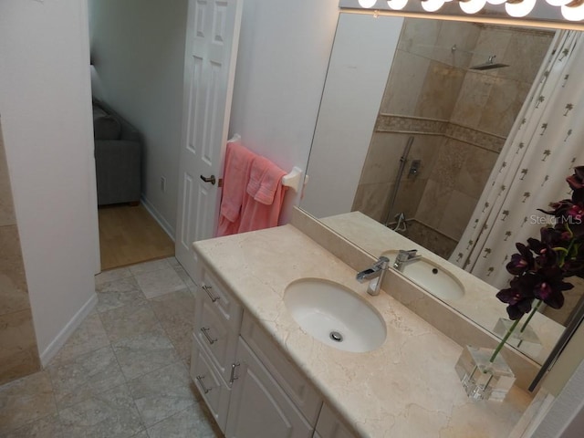 bathroom featuring vanity, baseboards, and a tile shower