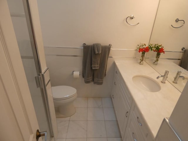 full bathroom with vanity, toilet, a shower stall, and tile patterned floors