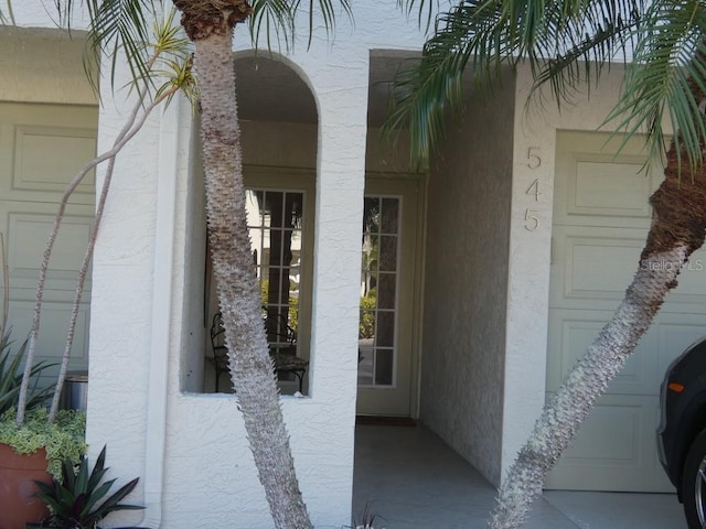 doorway to property featuring stucco siding