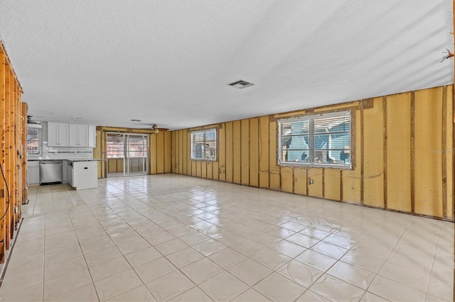 13815 Plumosa Ave, Hudson, FL 34667 - unfurnished living room with visible vents, wood walls, and a textured ceiling