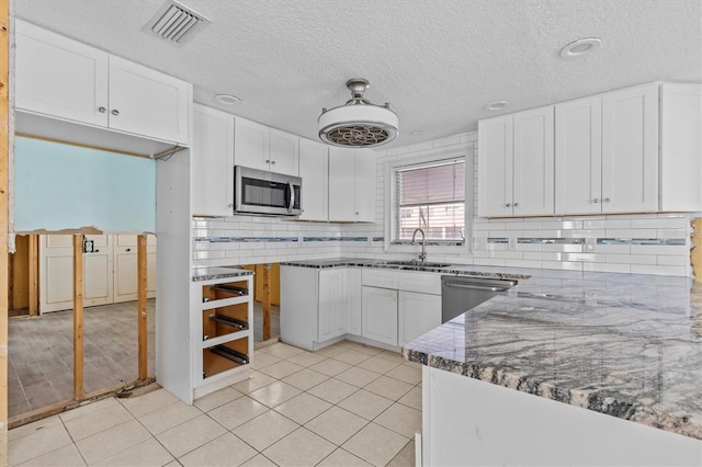 13815 Plumosa Ave, Hudson, FL 34667 - kitchen featuring visible vents, white cabinets, a sink, stainless steel appliances, and decorative backsplash