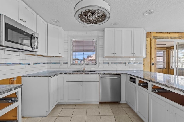 13815 Plumosa Ave, Hudson, FL 34667 - kitchen with white cabinets, a sink, a textured ceiling, stainless steel appliances, and stone counters