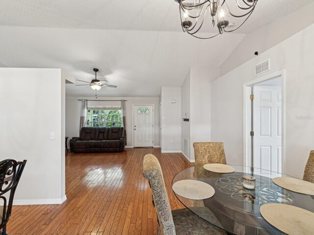 dining area featuring lofted ceiling, baseboards, visible vents, and wood-type flooring