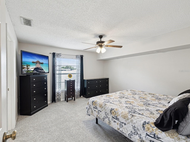 bedroom with carpet floors, a ceiling fan, a textured ceiling, and visible vents
