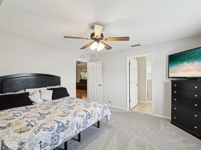 carpeted bedroom featuring a textured ceiling, visible vents, and a ceiling fan