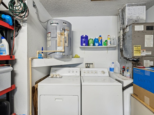 clothes washing area featuring washing machine and dryer, electric water heater, laundry area, and a textured ceiling