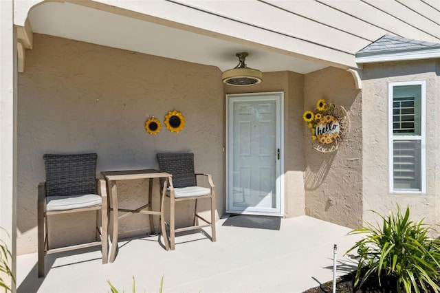 property entrance with a patio area and stucco siding