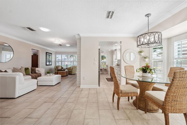 dining area with plenty of natural light, visible vents, a textured ceiling, and crown molding