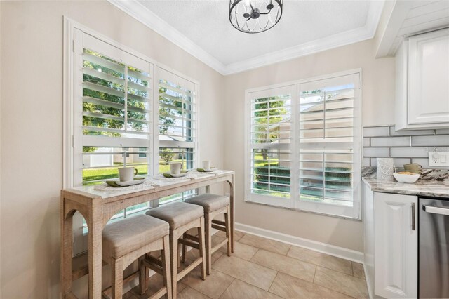 dining space with a chandelier, light tile patterned flooring, baseboards, and ornamental molding