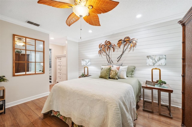 bedroom featuring ornamental molding, visible vents, recessed lighting, wood finished floors, and baseboards