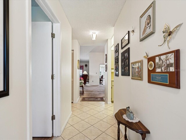 11536 Golden Rain Dr, New Port Richey, FL 34654 - corridor featuring a textured ceiling, light tile patterned floors, and baseboards