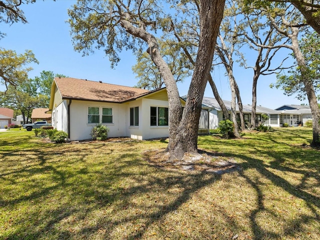 11536 Golden Rain Dr, New Port Richey, FL 34654 - rear view of property with stucco siding and a yard