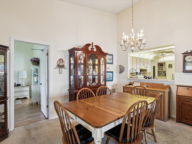 11536 Golden Rain Dr, New Port Richey, FL 34654 - dining space with light colored carpet, a chandelier, a towering ceiling, and a ceiling fan