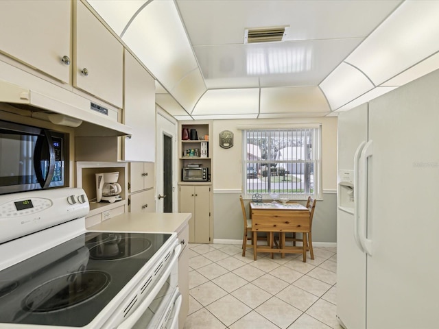 11536 Golden Rain Dr, New Port Richey, FL 34654 - kitchen featuring white appliances, light tile patterned floors, light countertops, under cabinet range hood, and baseboards