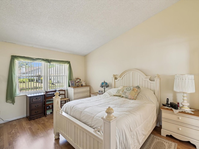 11536 Golden Rain Dr, New Port Richey, FL 34654 - bedroom with wood finished floors, a textured ceiling, and vaulted ceiling