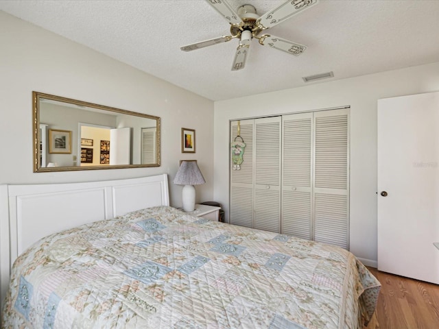 11536 Golden Rain Dr, New Port Richey, FL 34654 - bedroom featuring wood finished floors, a closet, a textured ceiling, and a ceiling fan