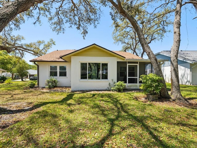 11536 Golden Rain Dr, New Port Richey, FL 34654 - back of property with a yard, stucco siding, a sunroom, and a shingled roof