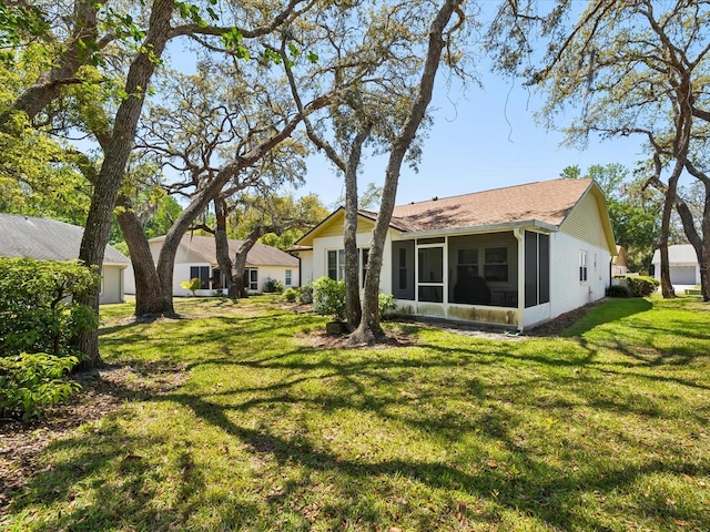 11536 Golden Rain Dr, New Port Richey, FL 34654 - back of property featuring a sunroom, a yard, and roof with shingles