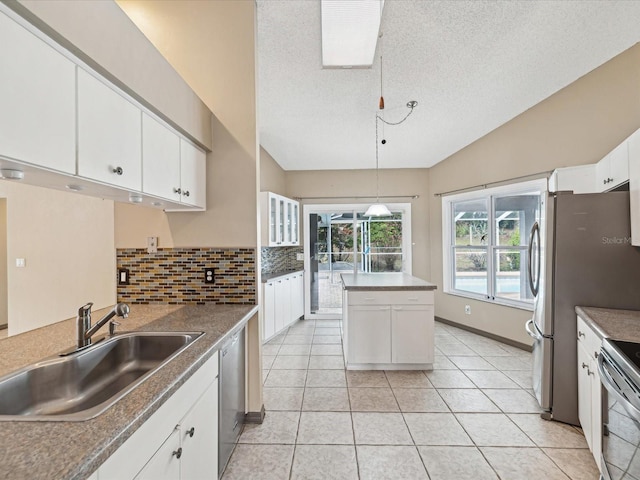 5411 Joyner Ave, Spring Hill, FL 34608 - kitchen featuring a textured ceiling, a sink, white cabinetry, decorative backsplash, and appliances with stainless steel finishes