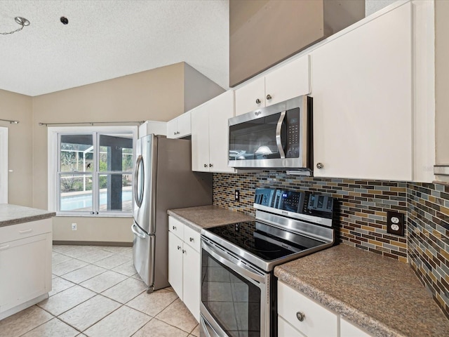 5411 Joyner Ave, Spring Hill, FL 34608 - kitchen featuring tasteful backsplash, a textured ceiling, light tile patterned floors, white cabinetry, and appliances with stainless steel finishes