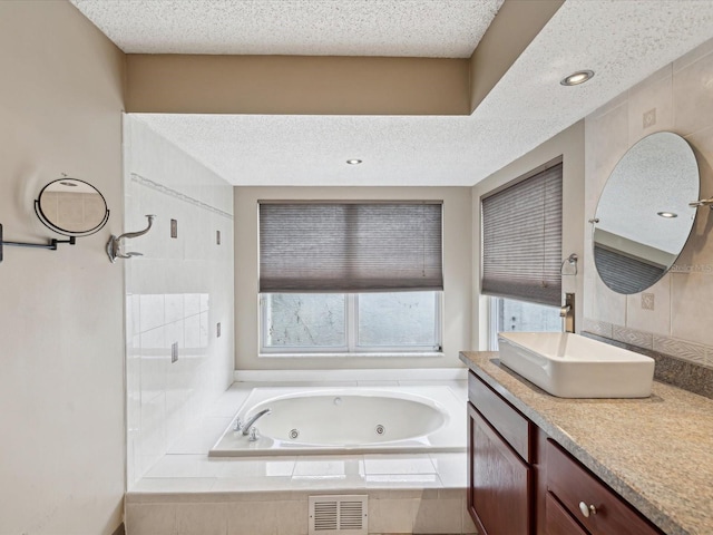5411 Joyner Ave, Spring Hill, FL 34608 - bathroom featuring a tub with jets, vanity, a textured ceiling, and visible vents