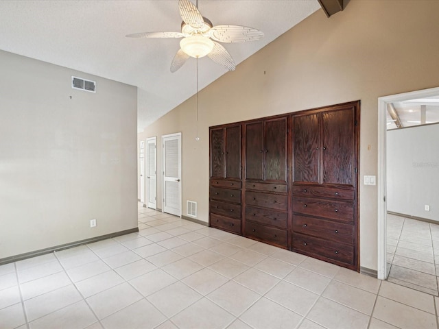 5411 Joyner Ave, Spring Hill, FL 34608 - unfurnished bedroom featuring baseboards, visible vents, high vaulted ceiling, and light tile patterned floors
