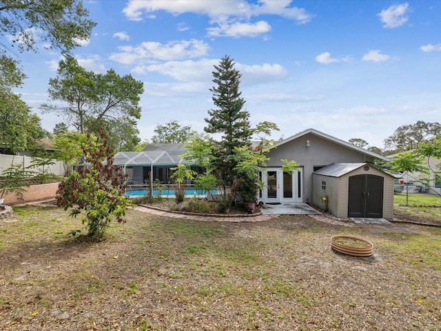 5411 Joyner Ave, Spring Hill, FL 34608 - rear view of house with a shed, an outdoor pool, french doors, an outdoor structure, and fence