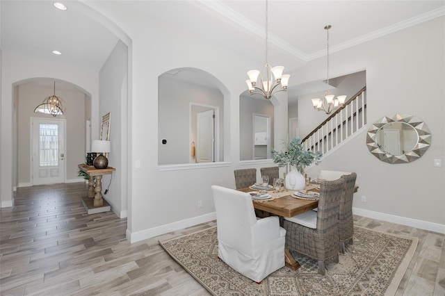 5070 Night Star Trl, Odessa, FL 33556 - dining room featuring a chandelier, light wood finished floors, arched walkways, baseboards, and ornamental molding